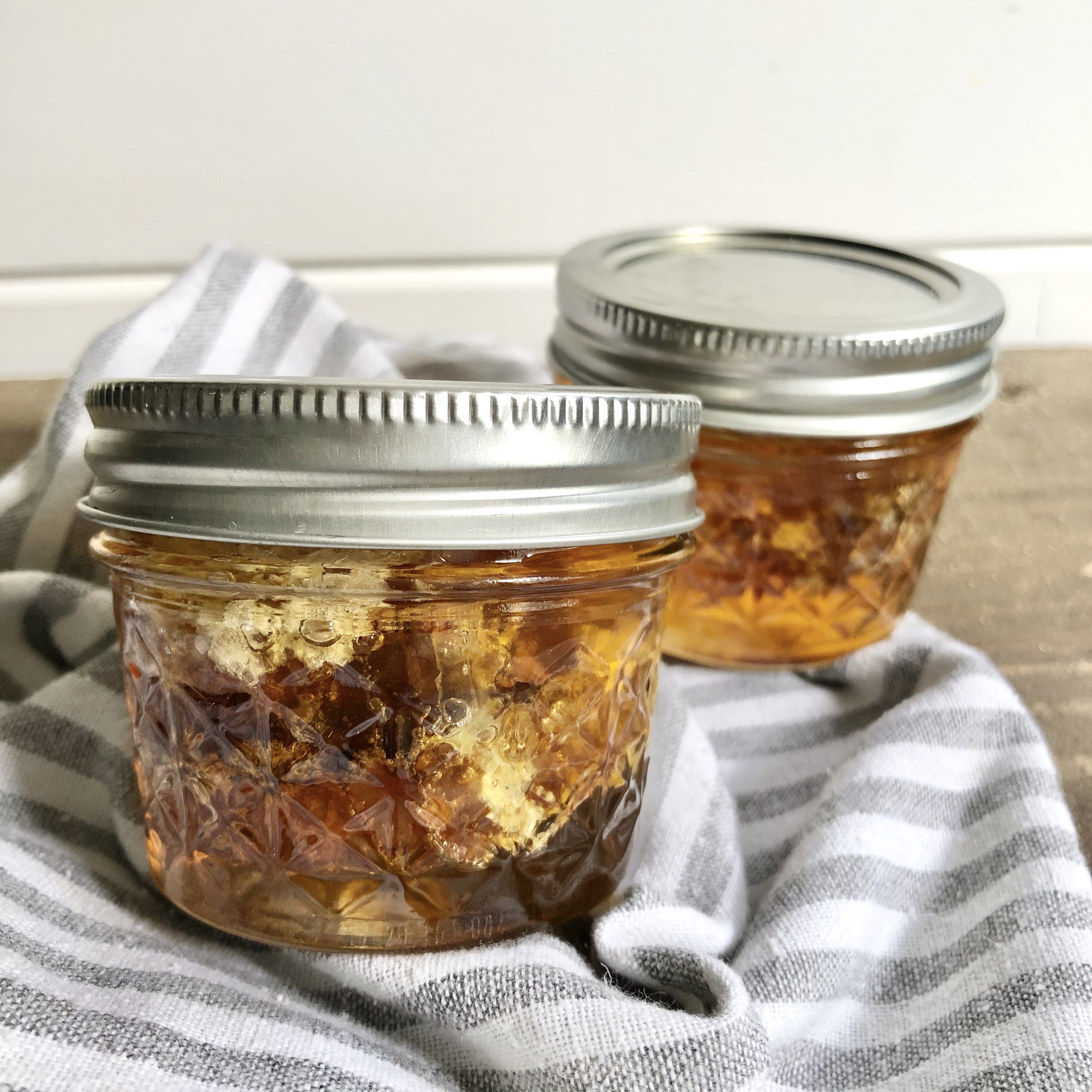 Two jars of honey on a piece of cloth